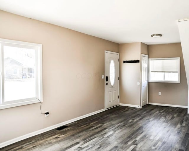 entrance foyer featuring baseboards and dark wood finished floors