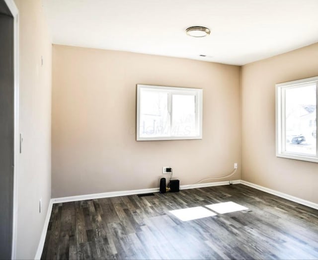 unfurnished room featuring baseboards and wood finished floors