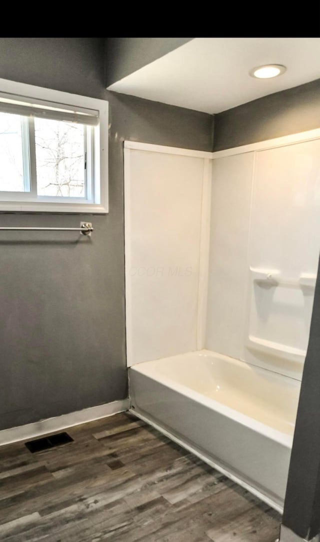 full bathroom with visible vents, baseboards, shower / washtub combination, and wood finished floors