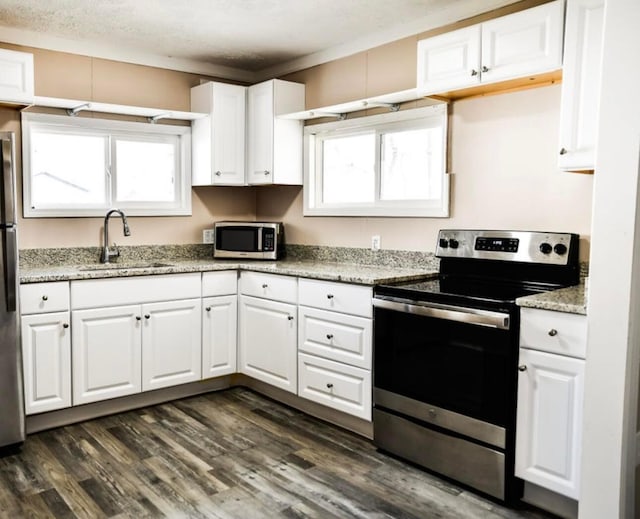 kitchen with white cabinets, dark wood-style floors, appliances with stainless steel finishes, and a sink