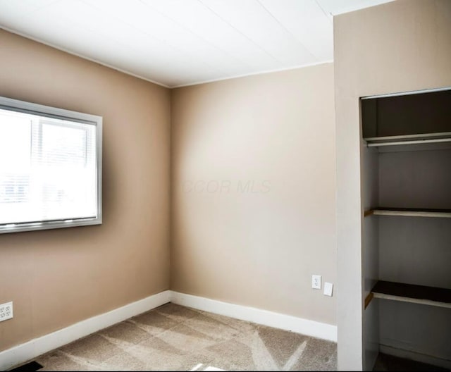 empty room with baseboards and light colored carpet