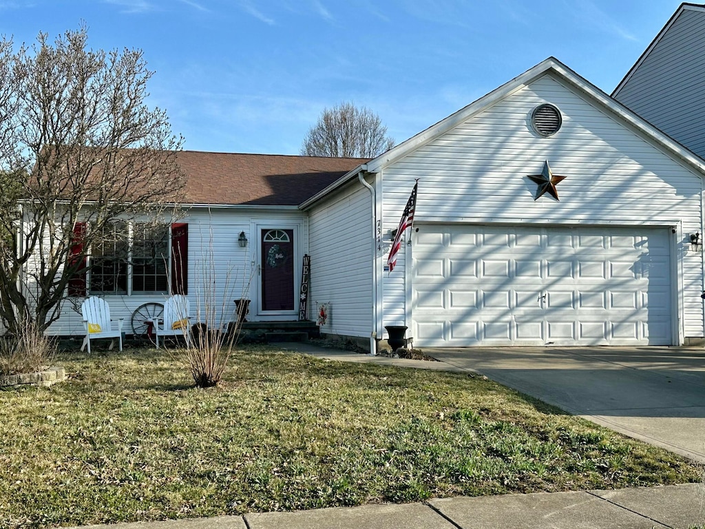 single story home with entry steps, a front yard, a garage, and driveway