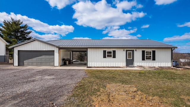 single story home with driveway, a garage, metal roof, an attached carport, and a front lawn