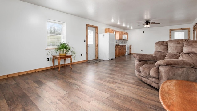 living room with wood finished floors, a ceiling fan, and baseboards