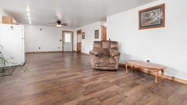 living area featuring ceiling fan, baseboards, and wood finished floors