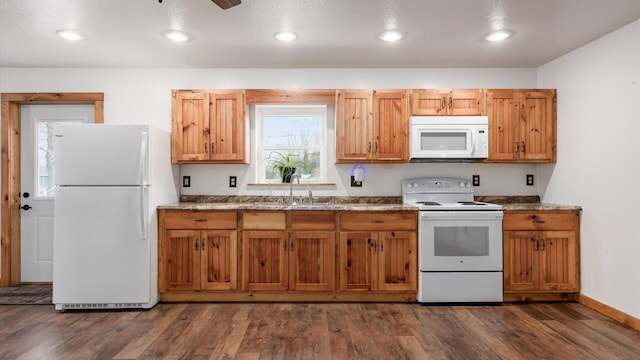 kitchen featuring white appliances, dark wood-style floors, a sink, and recessed lighting