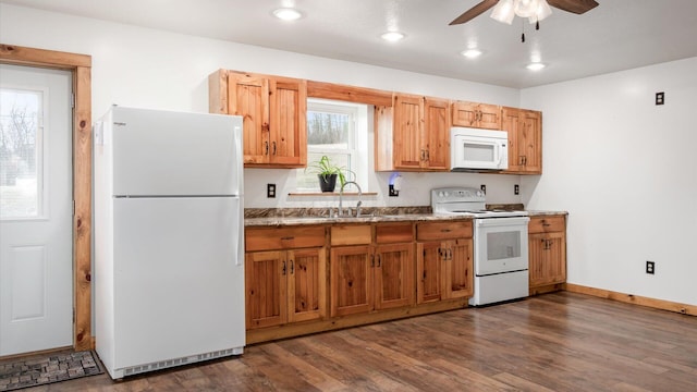 kitchen with dark wood-type flooring, a ceiling fan, a sink, white appliances, and baseboards