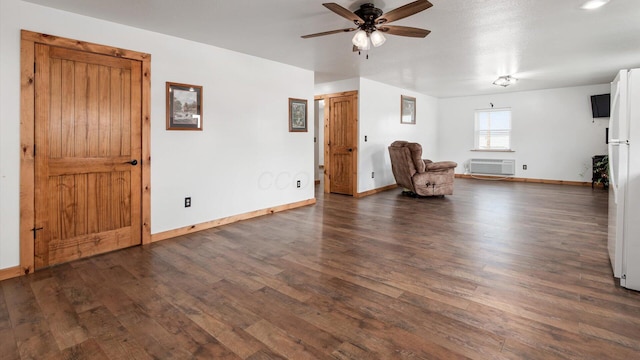 unfurnished room featuring dark wood-style floors, ceiling fan, baseboards, and an AC wall unit