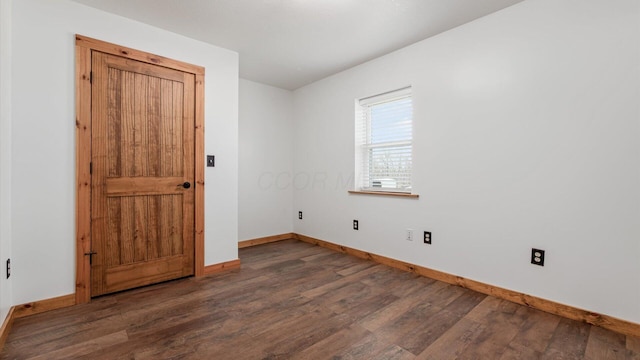 empty room with baseboards and wood finished floors