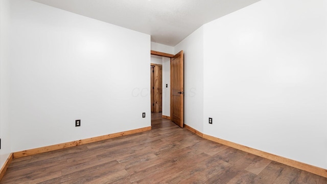 empty room featuring wood-type flooring and baseboards