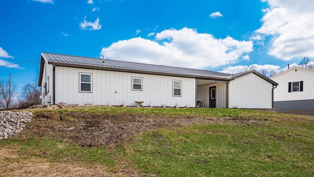 exterior space with a standing seam roof, metal roof, and a front lawn