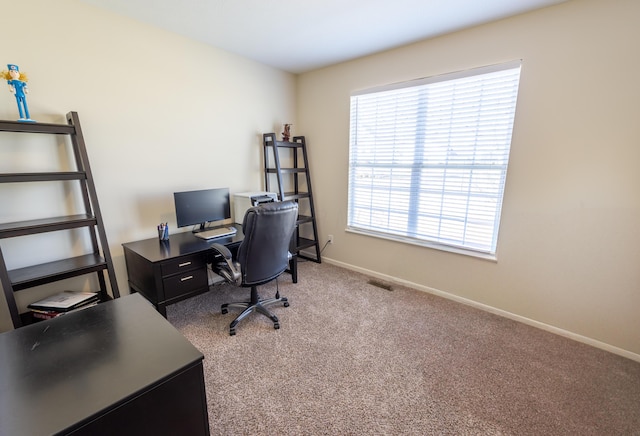 carpeted office space featuring visible vents and baseboards