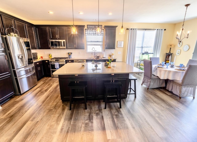 kitchen with a sink, light countertops, a breakfast bar, and stainless steel appliances