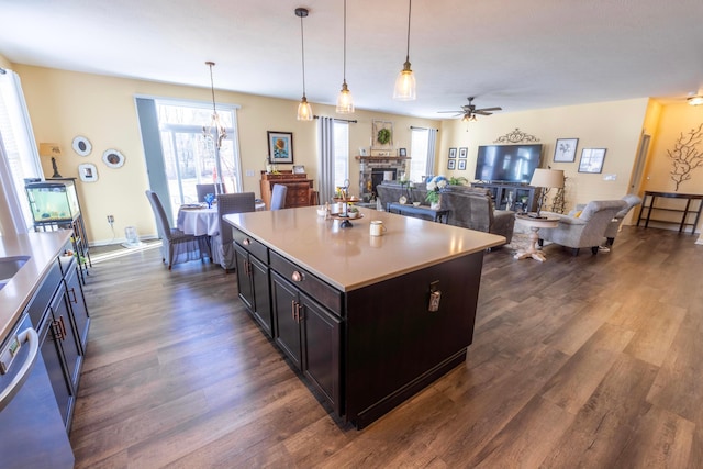 kitchen featuring dark wood-type flooring, decorative light fixtures, a fireplace, and light countertops