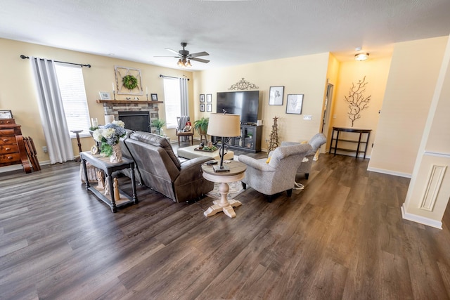 living room with ceiling fan, baseboards, dark wood-style flooring, and a fireplace