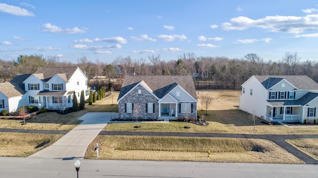 view of front facade with a residential view, a porch, driveway, and a front lawn