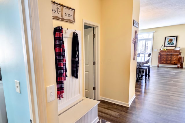 hall with baseboards and dark wood finished floors