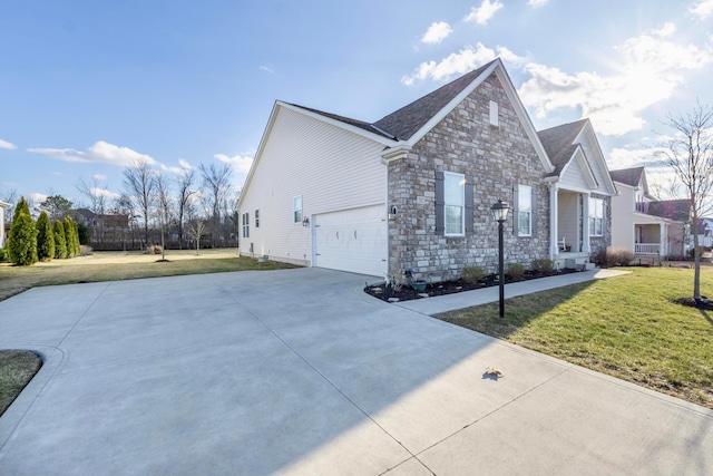 view of side of property with concrete driveway, a lawn, and stone siding