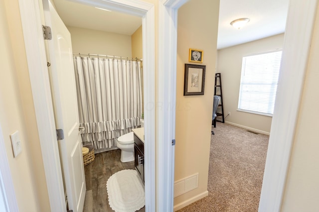 bathroom featuring vanity, visible vents, baseboards, curtained shower, and toilet