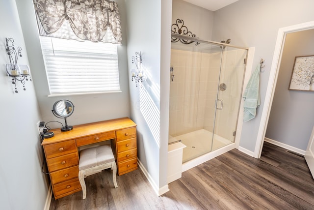 full bath with visible vents, wood finished floors, a stall shower, and baseboards