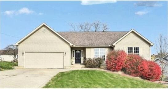 ranch-style home with a front lawn, driveway, and an attached garage