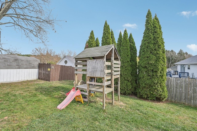 view of play area with a storage shed, a lawn, an outdoor structure, and a fenced backyard