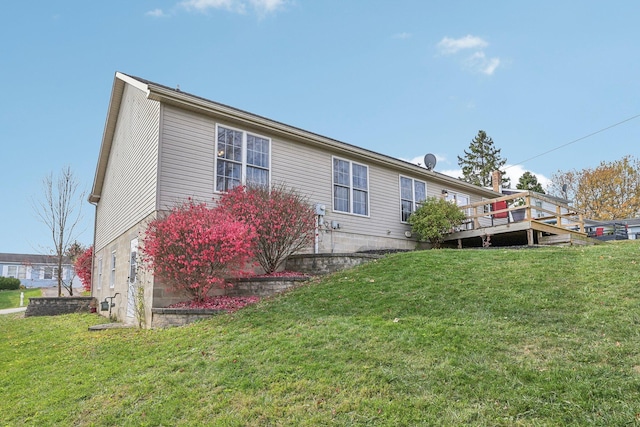 view of side of property with a deck and a yard