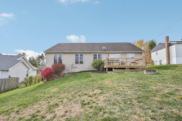 back of house with a lawn, a wooden deck, and fence