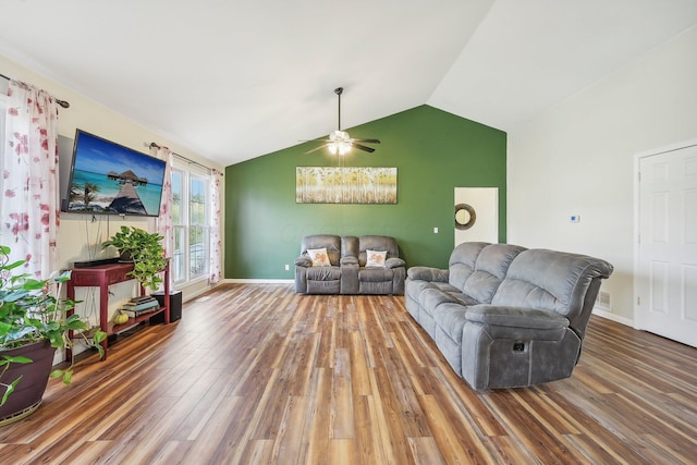 living room featuring lofted ceiling, ceiling fan, baseboards, and wood finished floors