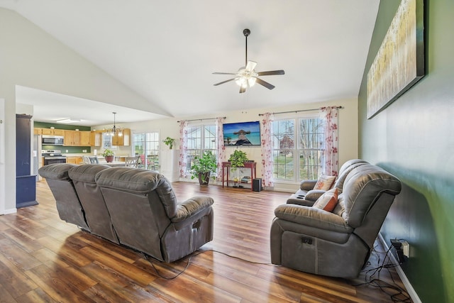 living room featuring high vaulted ceiling, ceiling fan with notable chandelier, baseboards, and wood finished floors