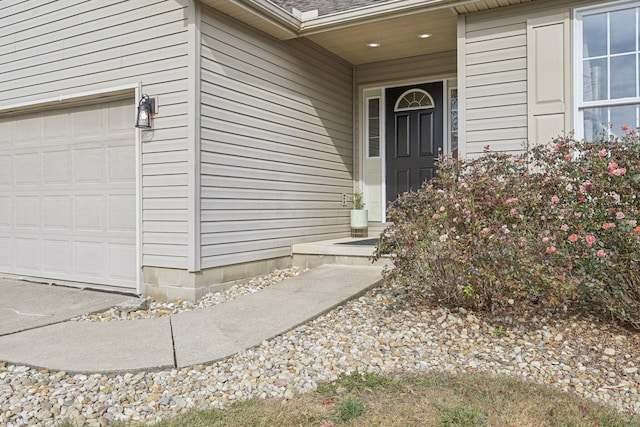 property entrance with a garage and roof with shingles