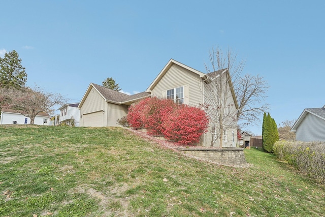 view of home's exterior with an attached garage and a lawn