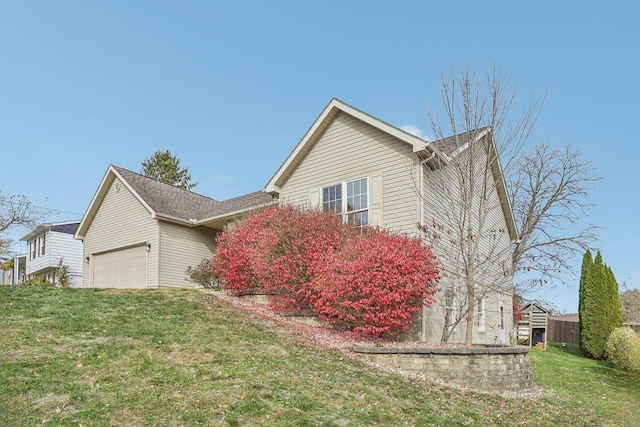 view of property exterior featuring an attached garage and a yard