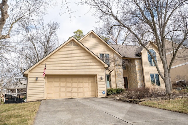 traditional home featuring stone siding, concrete driveway, and an attached garage