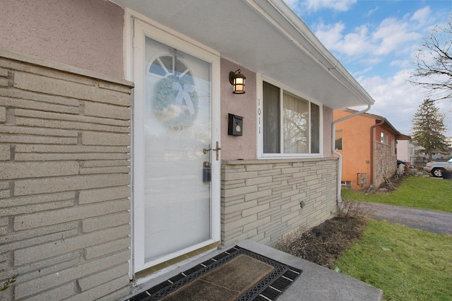 doorway to property featuring stucco siding