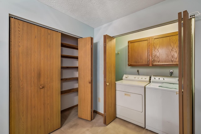 laundry area with light floors, cabinet space, a textured ceiling, washer and dryer, and baseboards