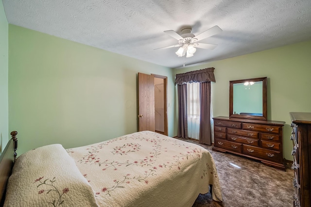 carpeted bedroom with a ceiling fan and a textured ceiling