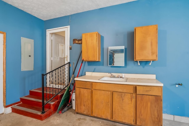 bathroom featuring a textured ceiling, electric panel, concrete flooring, and vanity