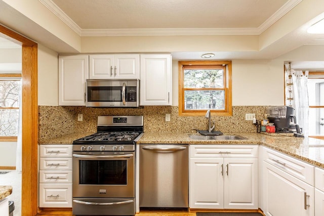 kitchen featuring white cabinetry, a sink, stainless steel appliances, and backsplash
