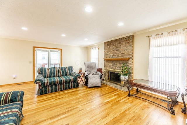 living area with wood finished floors, ornamental molding, and a healthy amount of sunlight