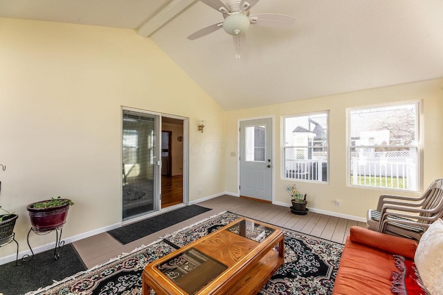 living room featuring baseboards, a wealth of natural light, a ceiling fan, and vaulted ceiling with beams