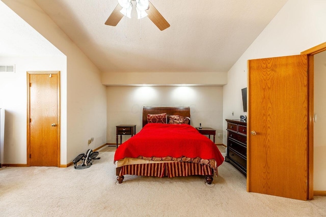 carpeted bedroom featuring a textured ceiling, visible vents, baseboards, a ceiling fan, and vaulted ceiling