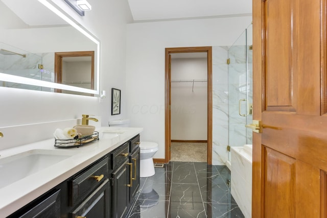 bathroom featuring a marble finish shower, a spacious closet, toilet, double vanity, and marble finish floor