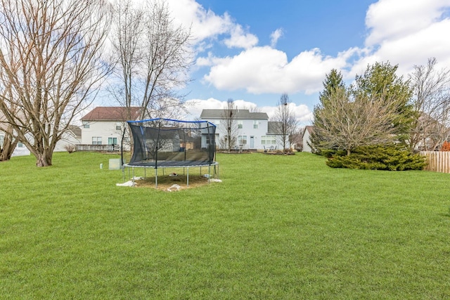 view of yard with a trampoline and fence