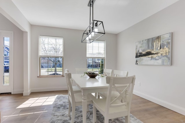 dining room with light wood-type flooring and baseboards