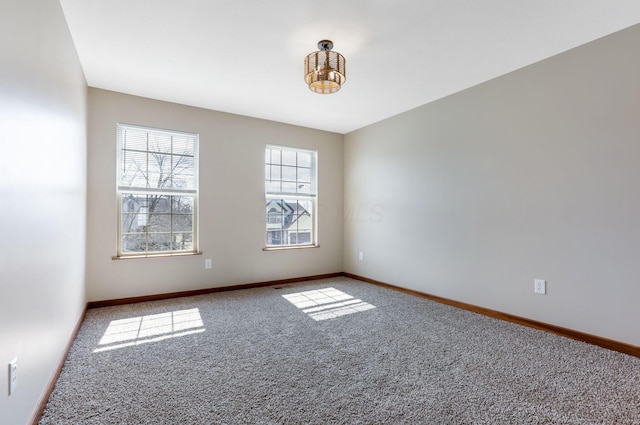 carpeted empty room featuring baseboards