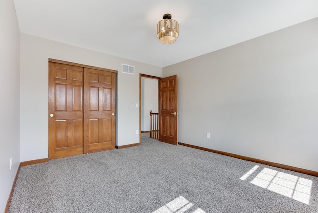 unfurnished bedroom featuring visible vents, baseboards, a closet, and carpet flooring