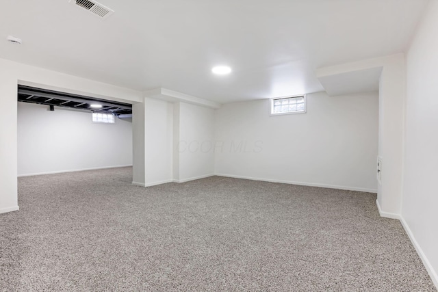 below grade area with carpet flooring, baseboards, and visible vents