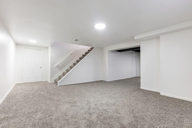 finished basement with baseboards, carpet, and stairs