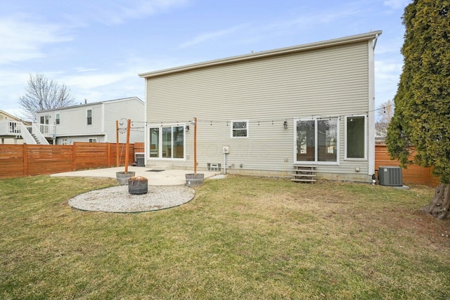 rear view of house with entry steps, a patio area, fence private yard, and a lawn